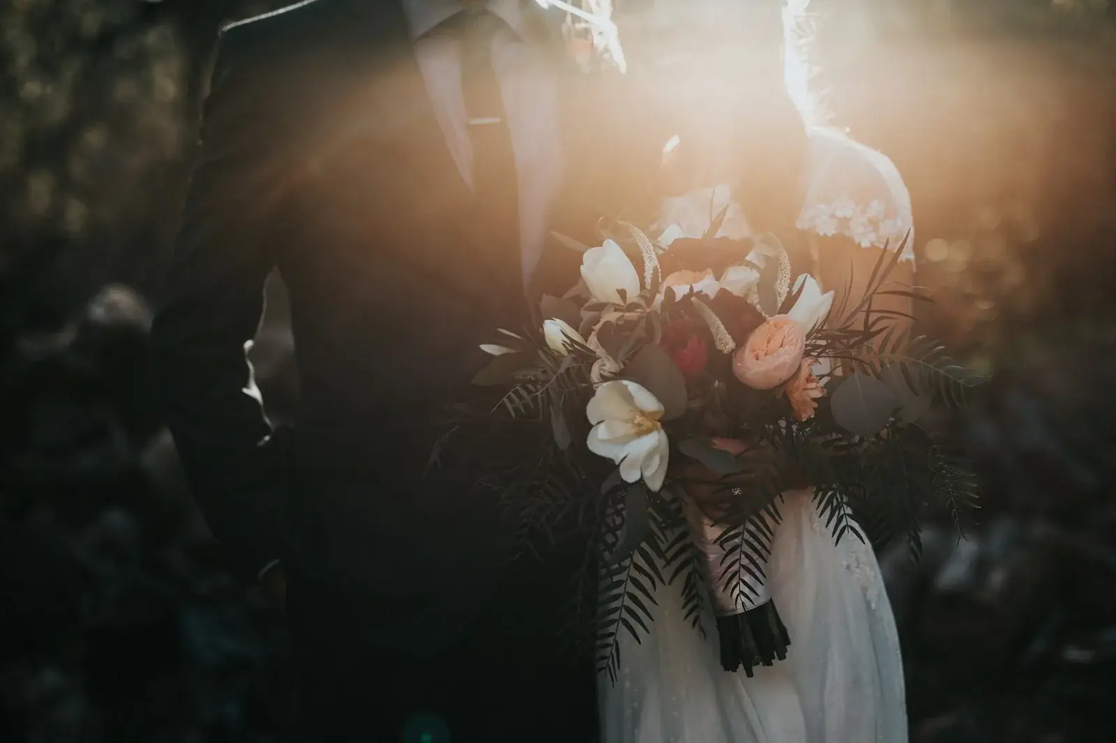 A bridal bouquet held in soft golden-hour light